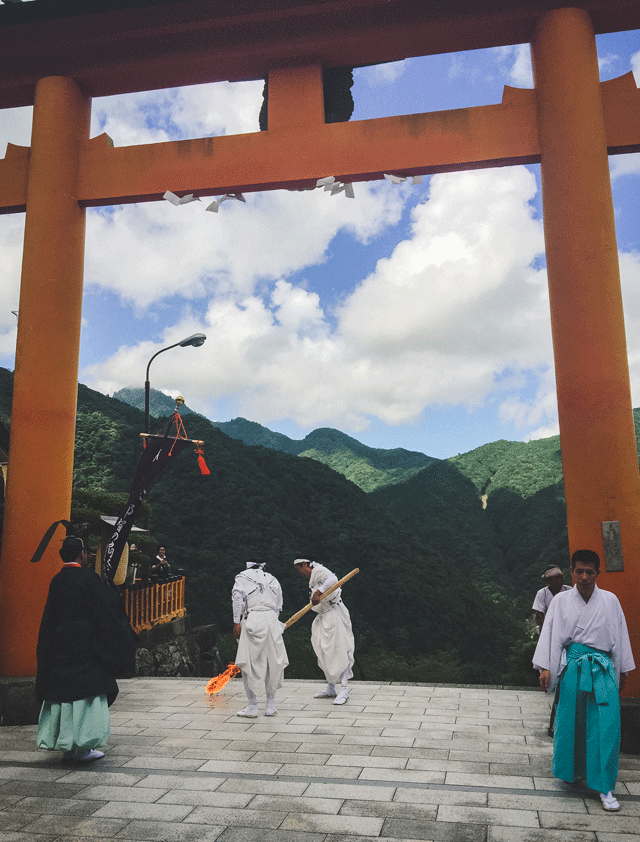Just before two in the afternoon, two white-robed men, overseen by the head priest, stepped to the edge of Kumano Nachi Taisha, and lit the first torch. The chain reaction started; a dozen others were quickly lit – these sacred flames would be used for the much larger torches later, near the falls. The men then lead the procession down the steep steps, a parade of monks, the head priest, maiko, and volunteers, towards the waterfall. The annual event has started the same way for more than fifteen hundred years.
