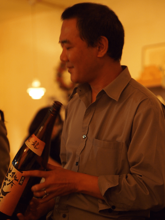 a man holding a bottle of sake