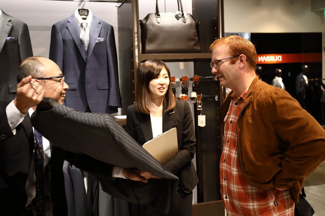 Customer looks at D'URBAN men's suits Tokyo Weekender