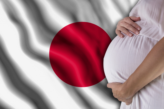 pregnant belly next to Japanese flag background
