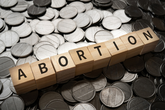 abortion lettering over money background